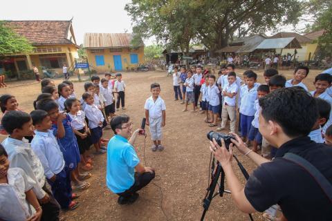 A proud seven-year-old boy is getting ready to be interviewed by two video trainees in a school located in Kandal Province, Cambodia on February 8, 2017. The growth of internet and social media usage in Cambodia has open up a whole new platform for video storytelling, and the demand for video production skills in Cambodia has skyrocketed in the past three years. Development Innovations provides courses in Khmer to help meet this need for beginner level videographers.     Photo Credit: Chandy Mao, Developmen